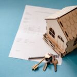 miniature house with documents and keys