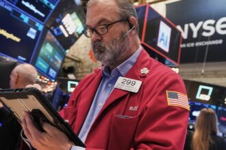 Stock market hits record high as concerns about AI bubble persist